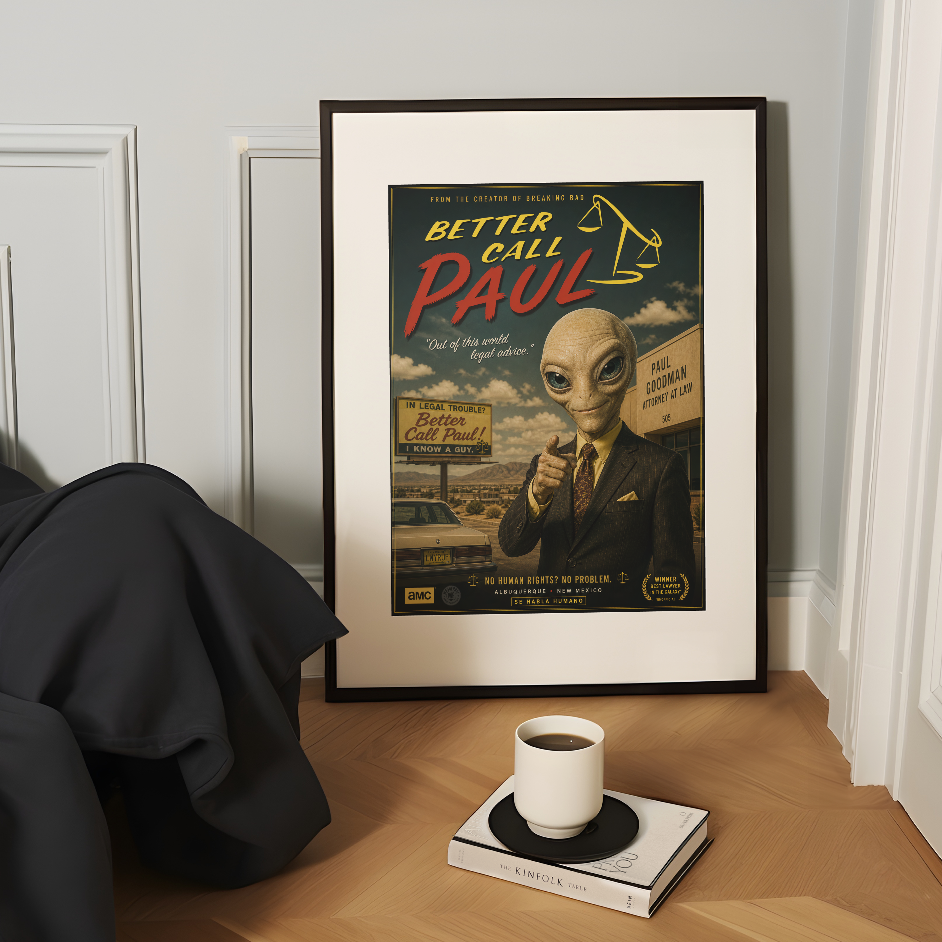 Framed poster of 'Better Call Paul' with an alien in a suit on a wooden surface with a cup and book.