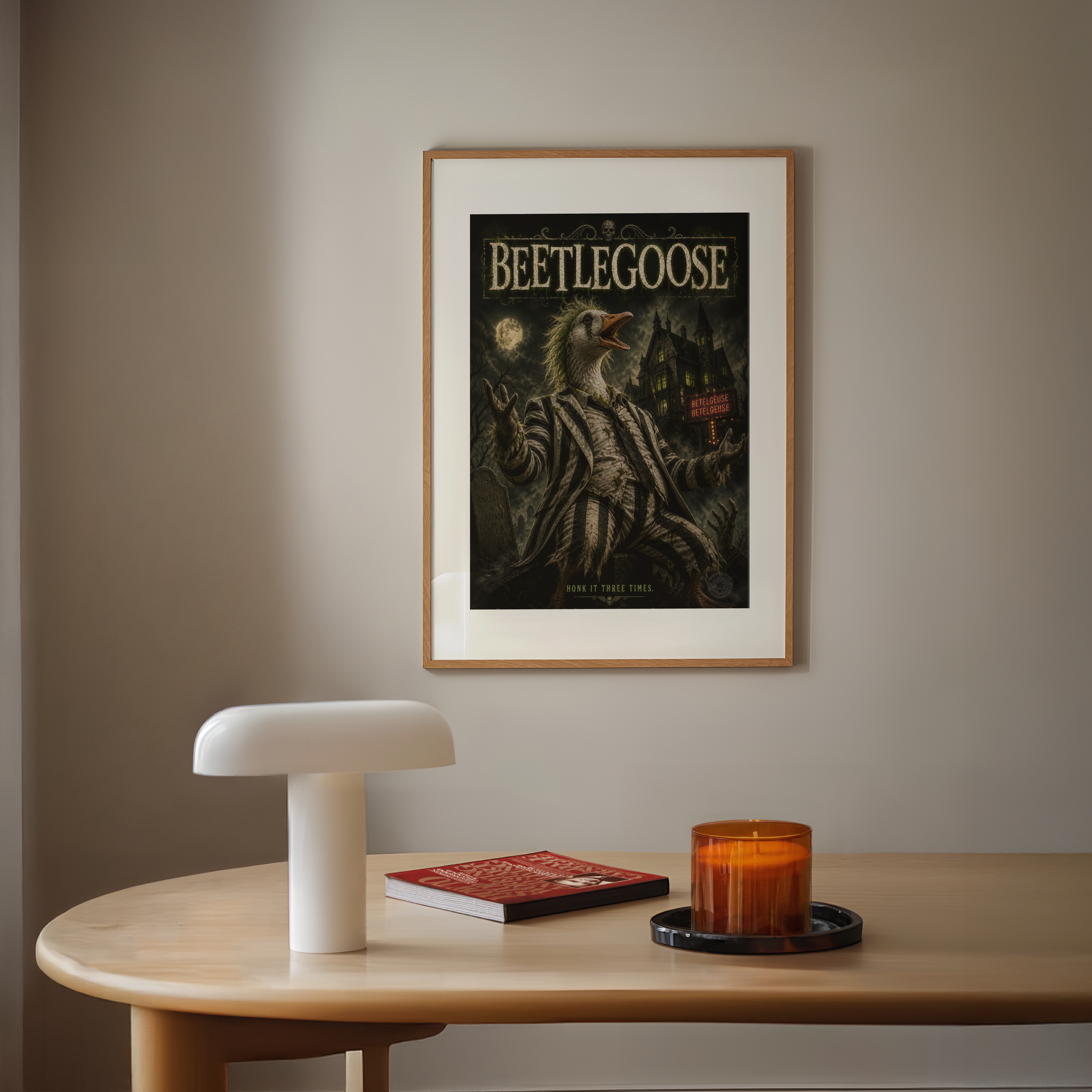 Framed 'Beetlegoose' poster on a wall above a wooden table with a lamp, book, and candle.