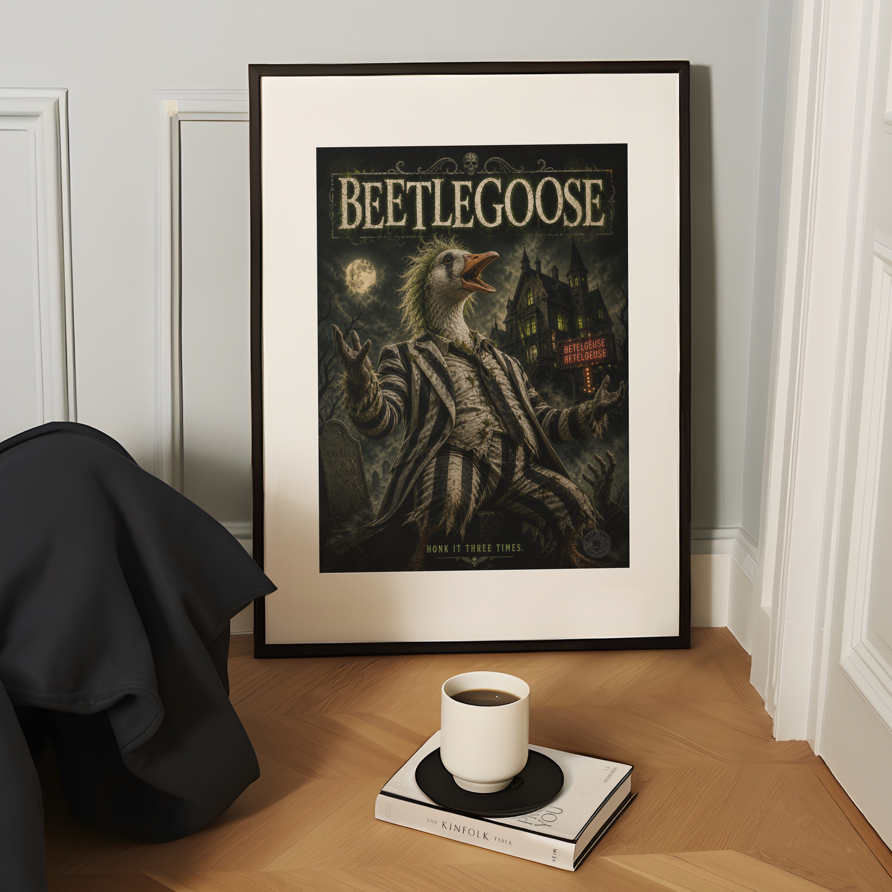 Framed 'Beetlegoose' poster on a wooden surface with a cup of coffee and book.