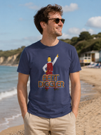 A man wearing a navy blue graphic t-shirt with a 'Bert Diggler' design, standing on a sandy beach with the ocean and sky in the background.