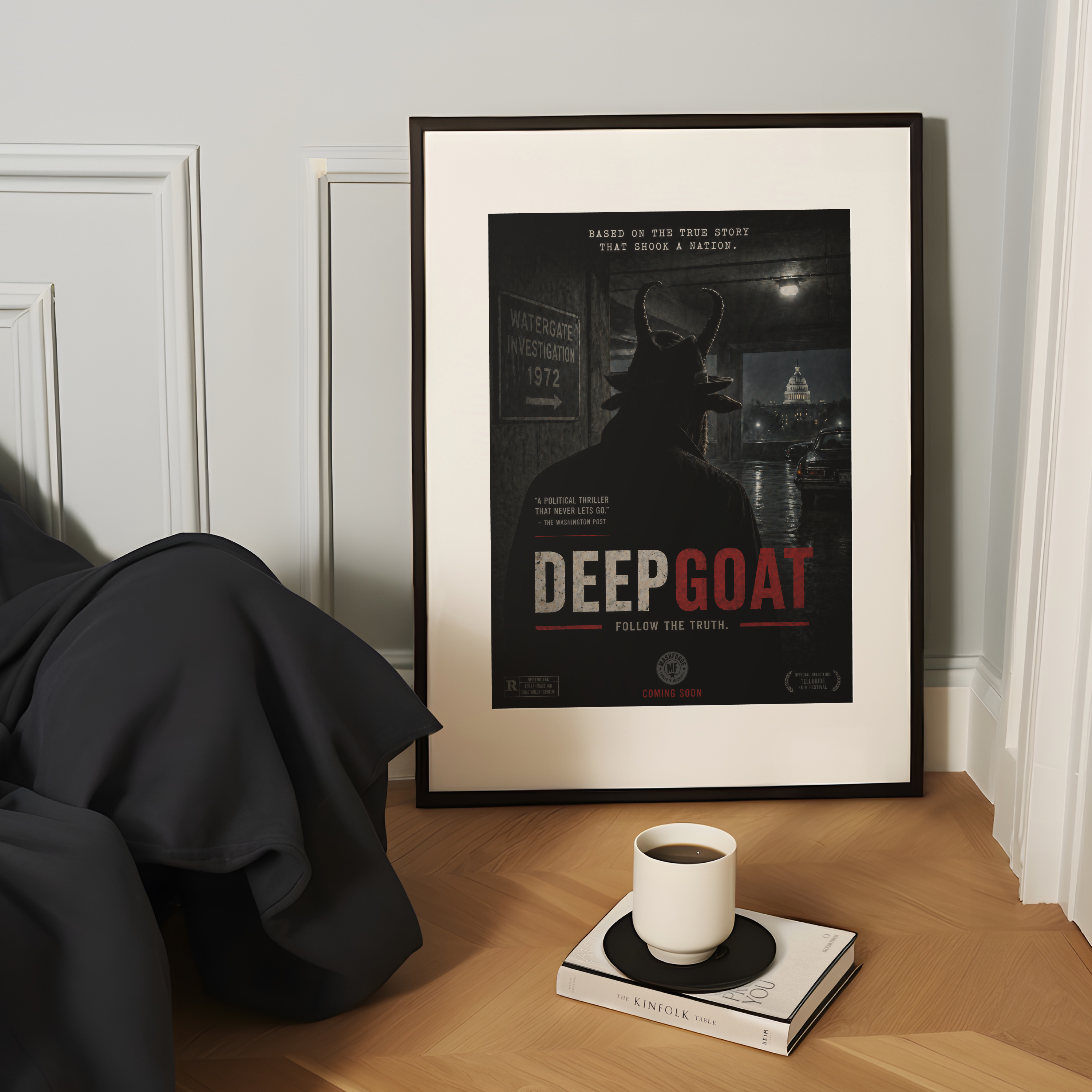 Framed poster titled 'Deep Goat' on a wooden surface with a cup and book.