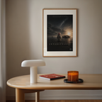Framed 'Interstellar' cartoon pig movie poster on a wall above a wooden table with decor items.