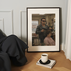 Framed poster of a woman getting a haircut from the terminator on a table with a coffee cup and book.