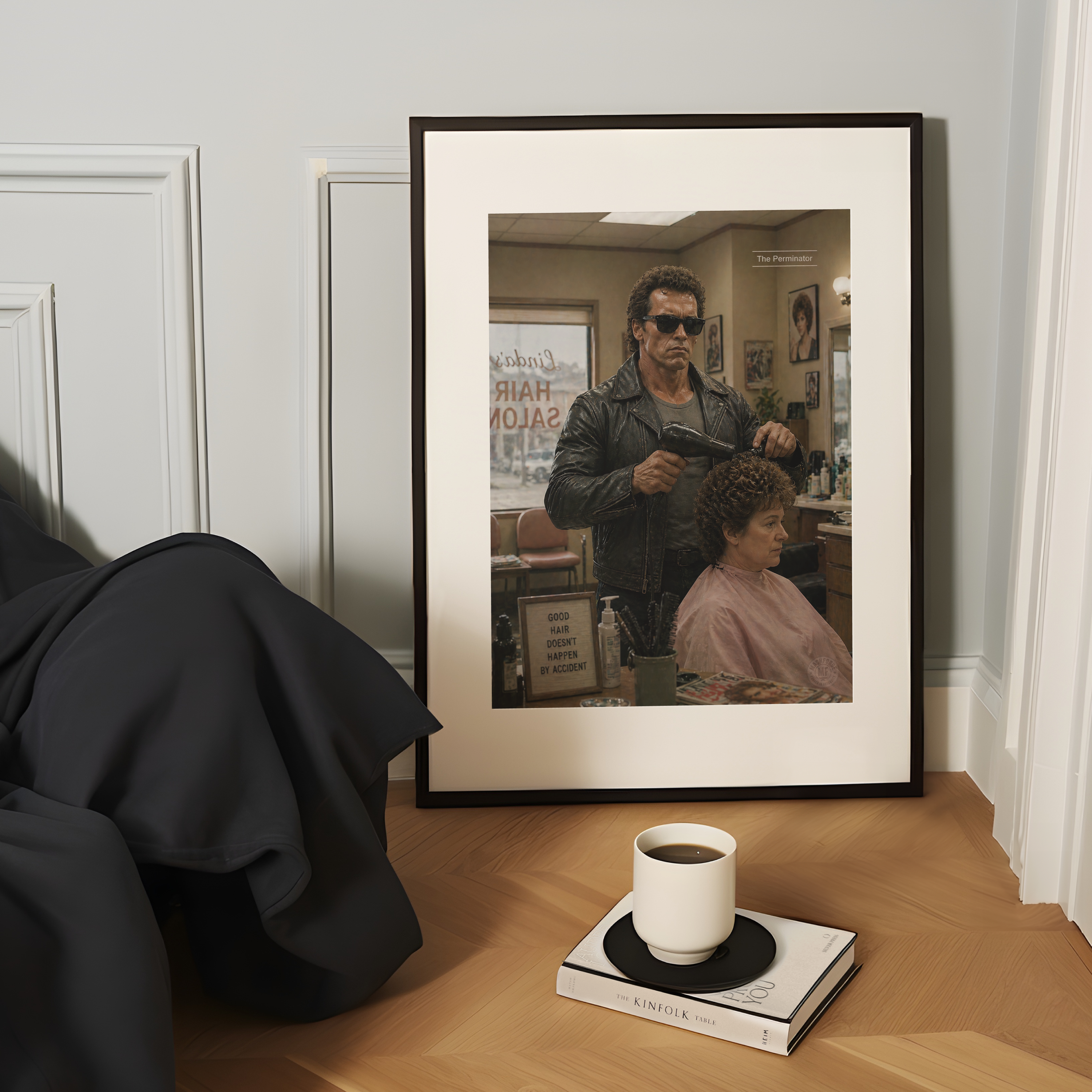 Framed poster of a woman getting a haircut from the terminator on a table with a coffee cup and book.