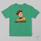 A green crewneck t-shirt featuring a graphic print of Captain Tam O'Shatner from Star Trek wearing a red tartan beret and a gold command uniform, with 'TAM O'SHATNER' printed below. The t-shirt is displayed flat against a neutral gray background.