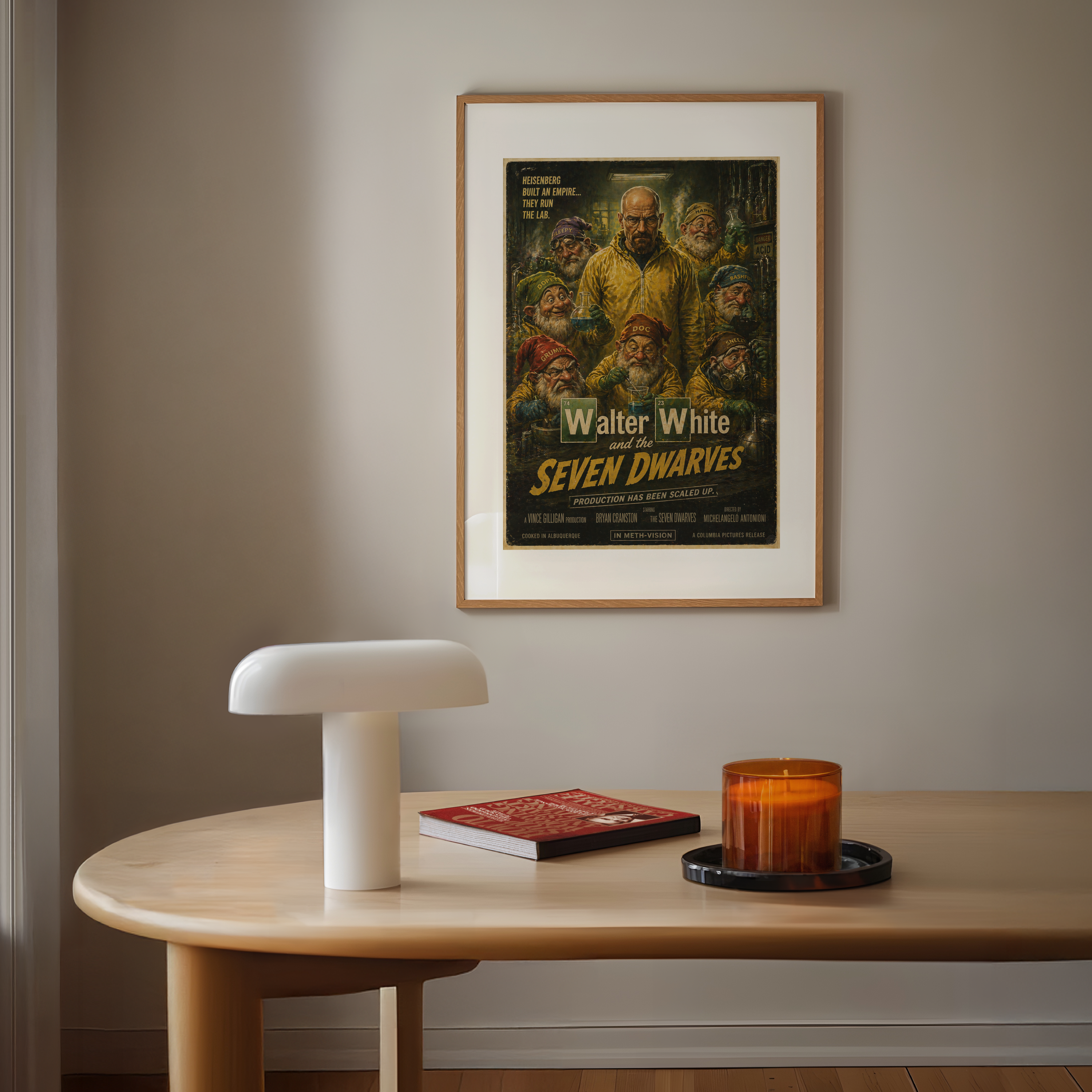 Framed movie poster on a wall above a wooden table with a lamp, book, and candle.