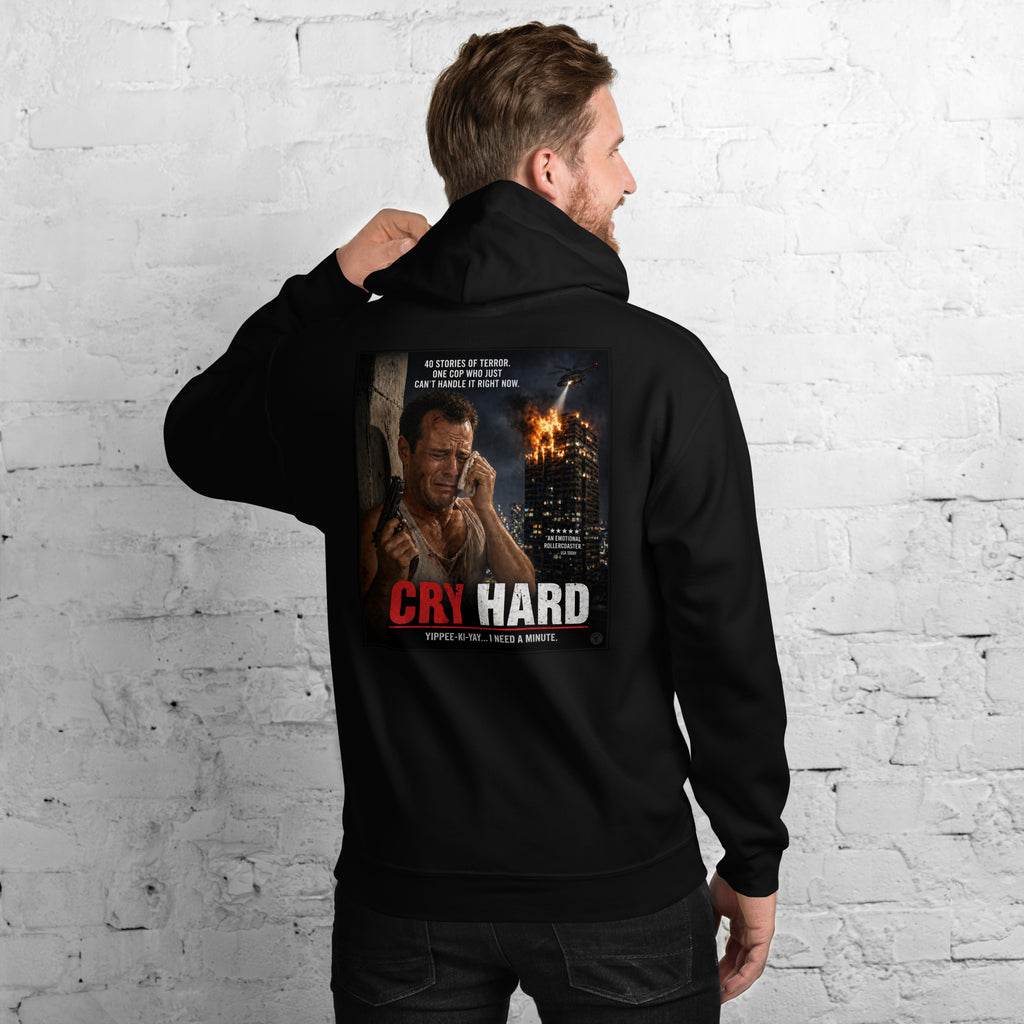 Man wearing a black hoodie with a graphic print and text 'Die Hard' on the back, against a white brick wall.
