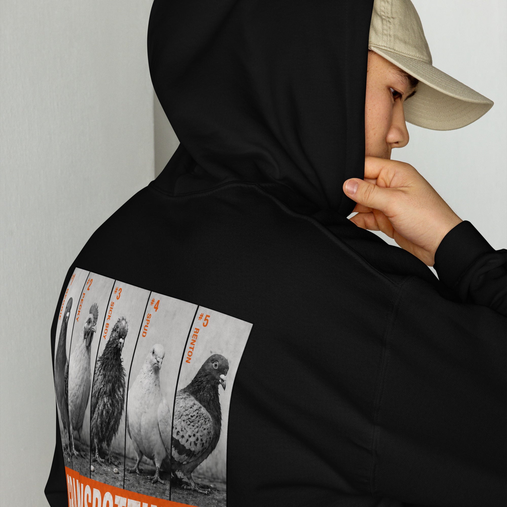 Person wearing a black hoodie with pigeon illustrations on the back, against a plain background