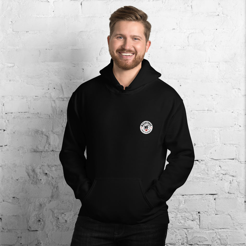 Man wearing a black hoodie with a logo on a white brick wall