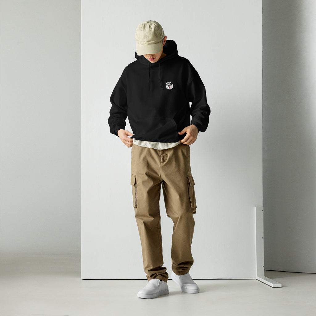 Person wearing a mashforge black hoodie, beige cap, and brown cargo pants against a white background