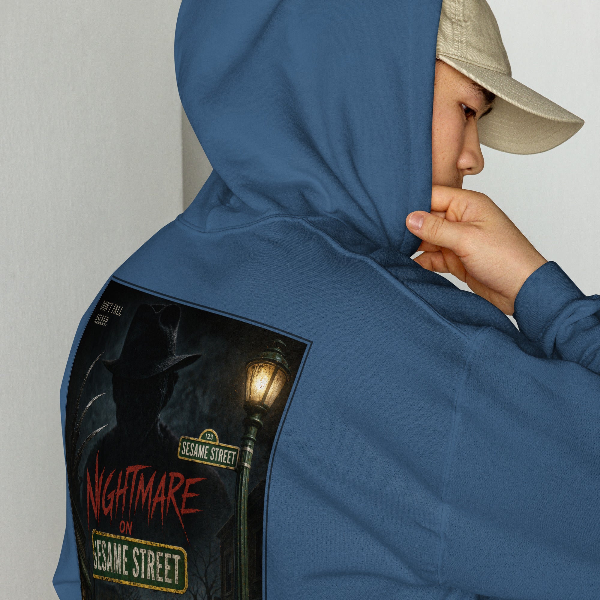 Person wearing a blue hoodie with a 'Nightmare on Sesame Street' graphic design.