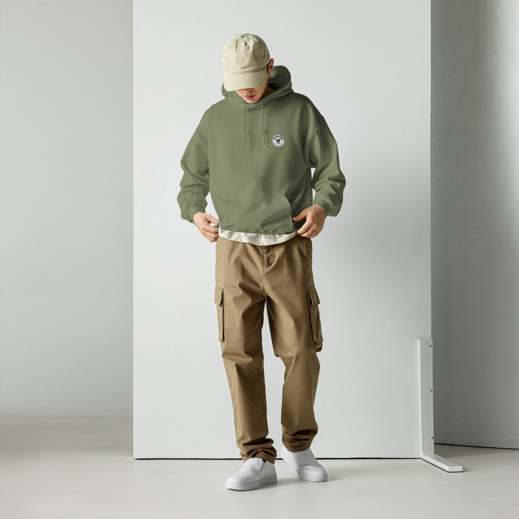 Person wearing a green hoodie with mashforge logo and brown cargo pants on a white background
