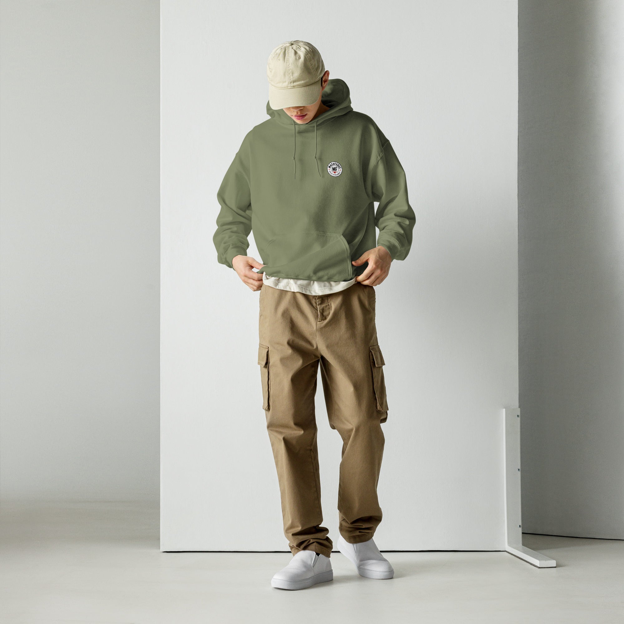 Person wearing a green hoodie with mashforge logo and brown cargo pants on a white background