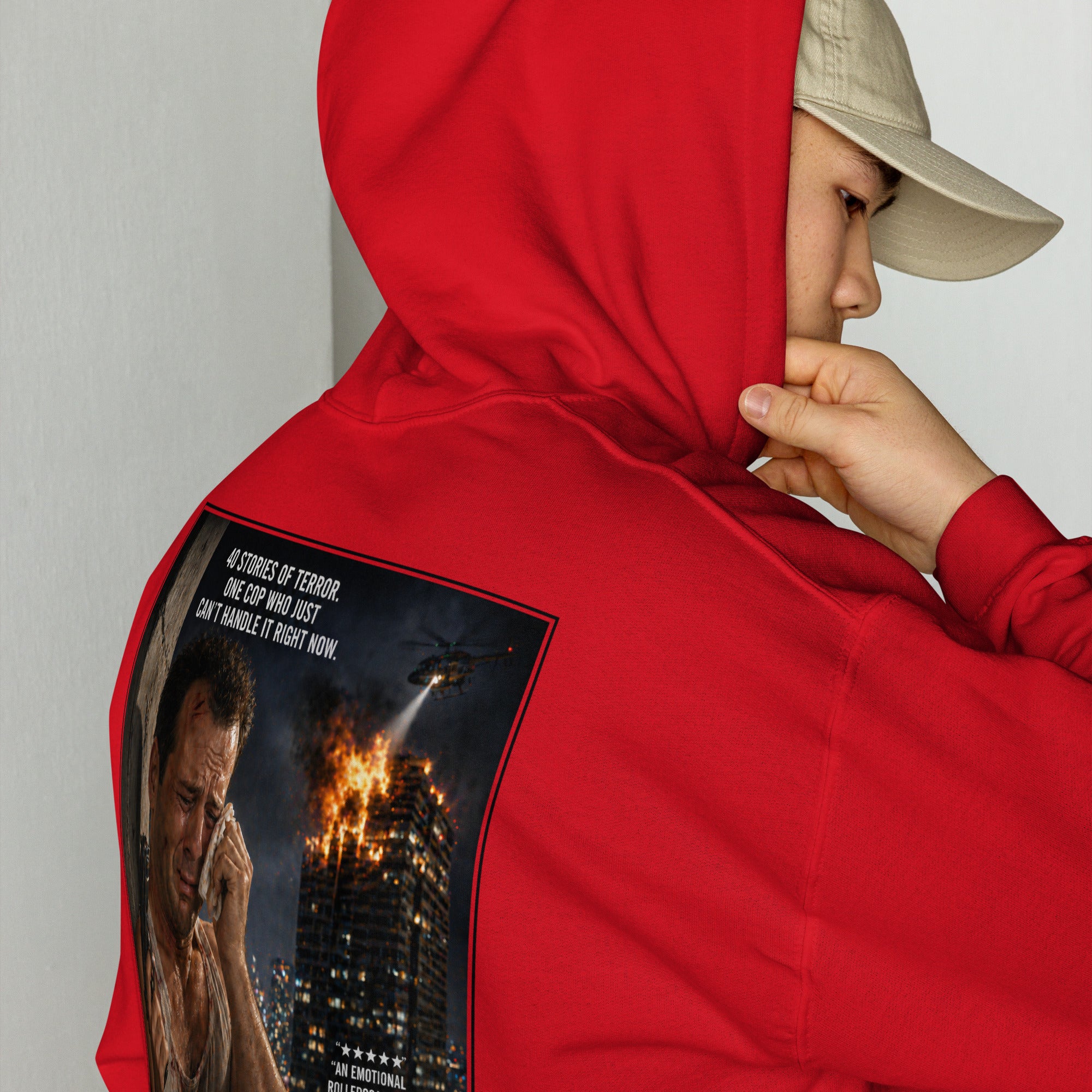 Person wearing a red hoodie with a graphic design on the back, featuring a Die Hard movie poster.