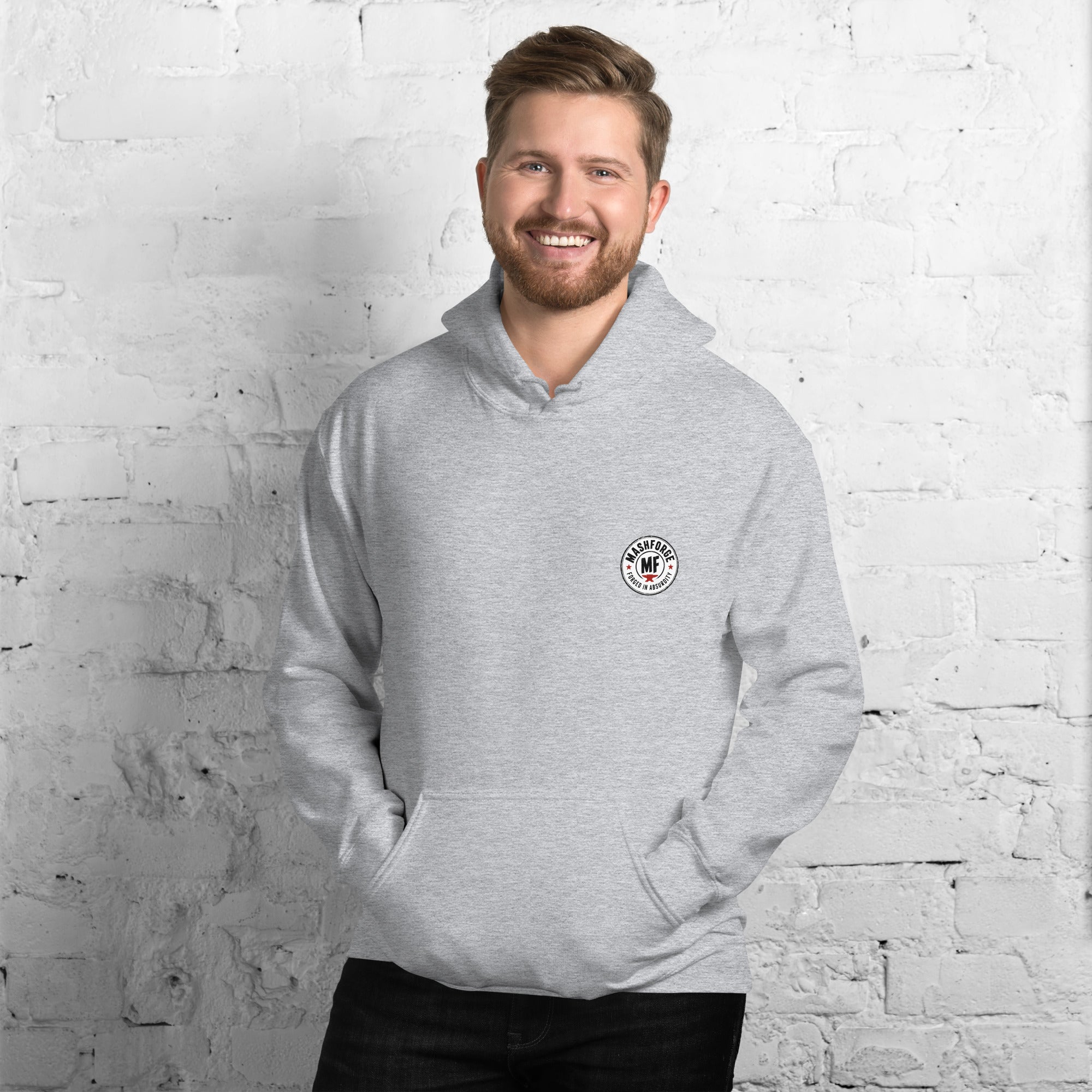 Man wearing a mashforge gray hoodie with 'dog dad' text against a white brick wall.