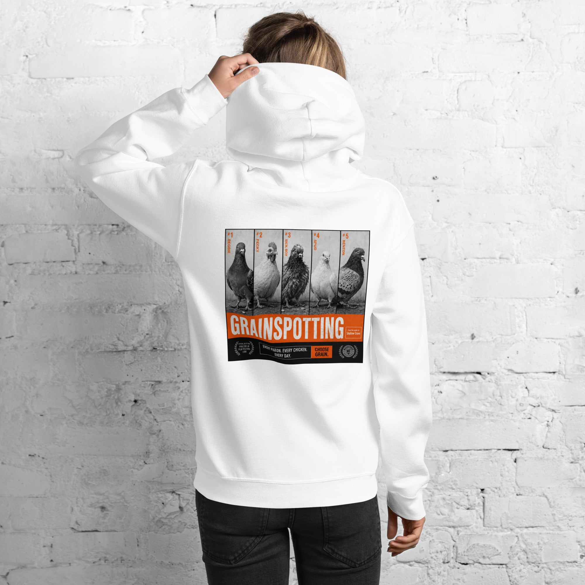Person wearing a white hoodie with 'Grainspotting' graphic on the back against a white brick wall.