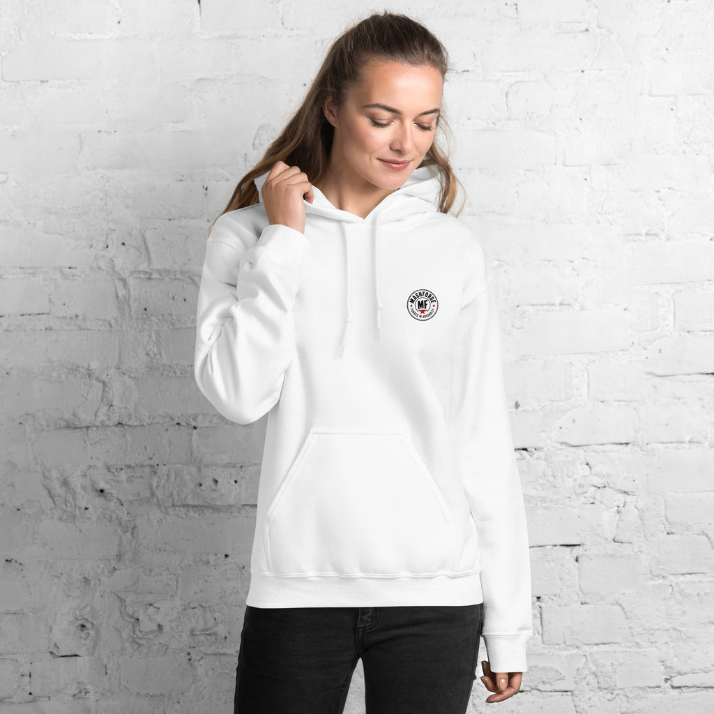 Woman wearing a white mashforge hoodie with a logo against a white brick wall