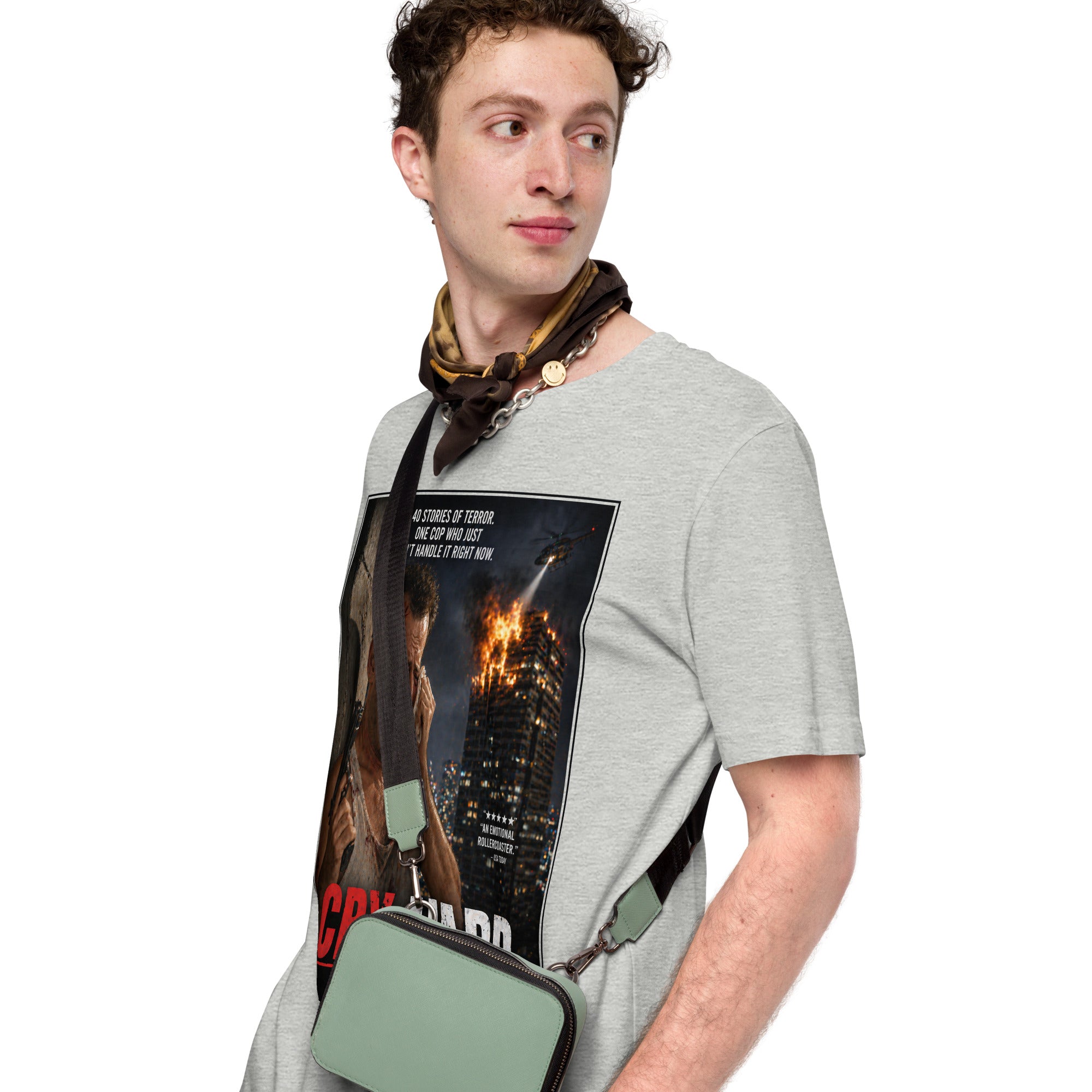 Man wearing a gray t-shirt with a graphic design and holding a green bag on a white background