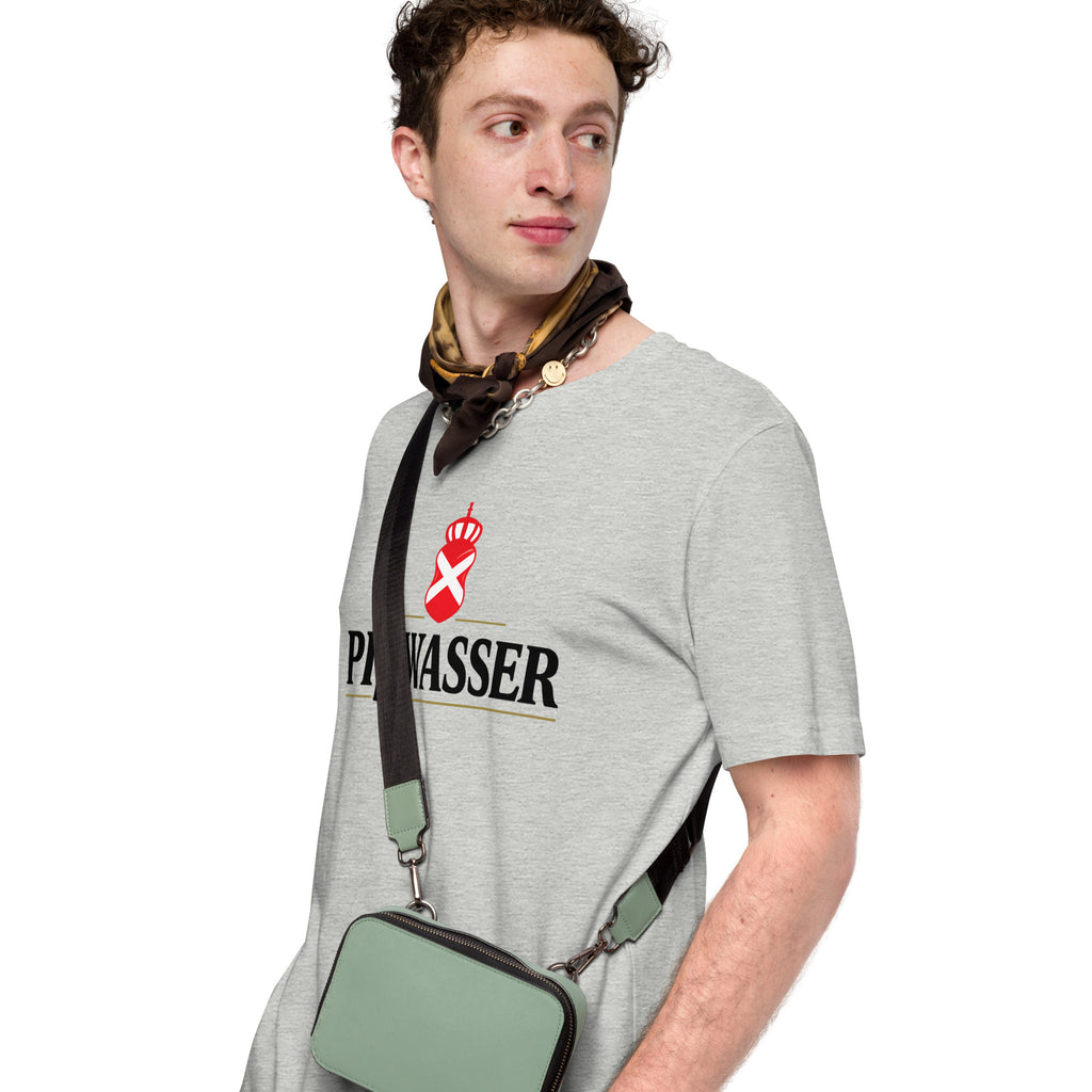 A man wearing a light gray crewneck t-shirt with a black and red 'PiBWASSER' logo on the chest, styled with a patterned neck scarf and a sage green crossbody bag with a black strap.