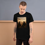Man wearing a black t-shirt with a graphic design on a plain background