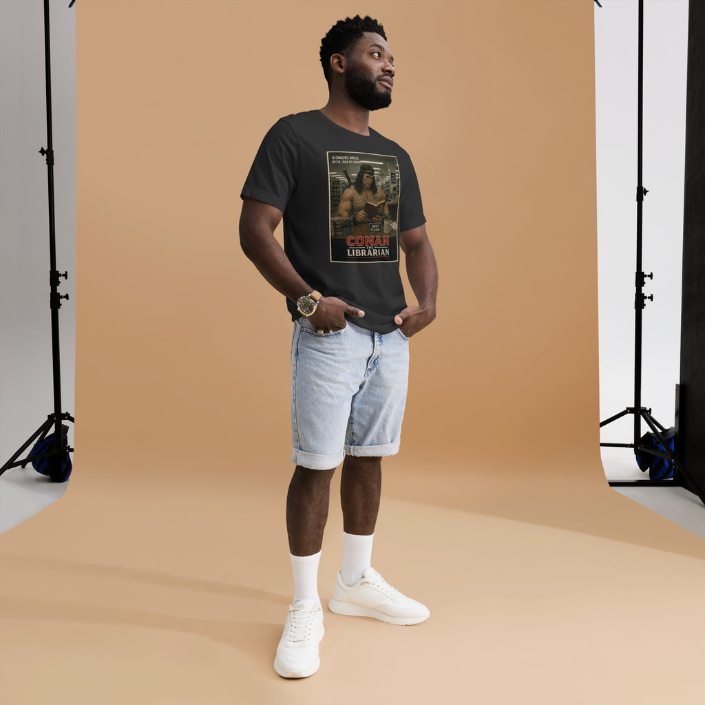 Man wearing a black t-shirt with a graphic design and text, standing against a brown backdrop in a studio setting.