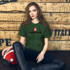 Woman in a green t-shirt sitting against a wooden wall with a helmet on her lap.