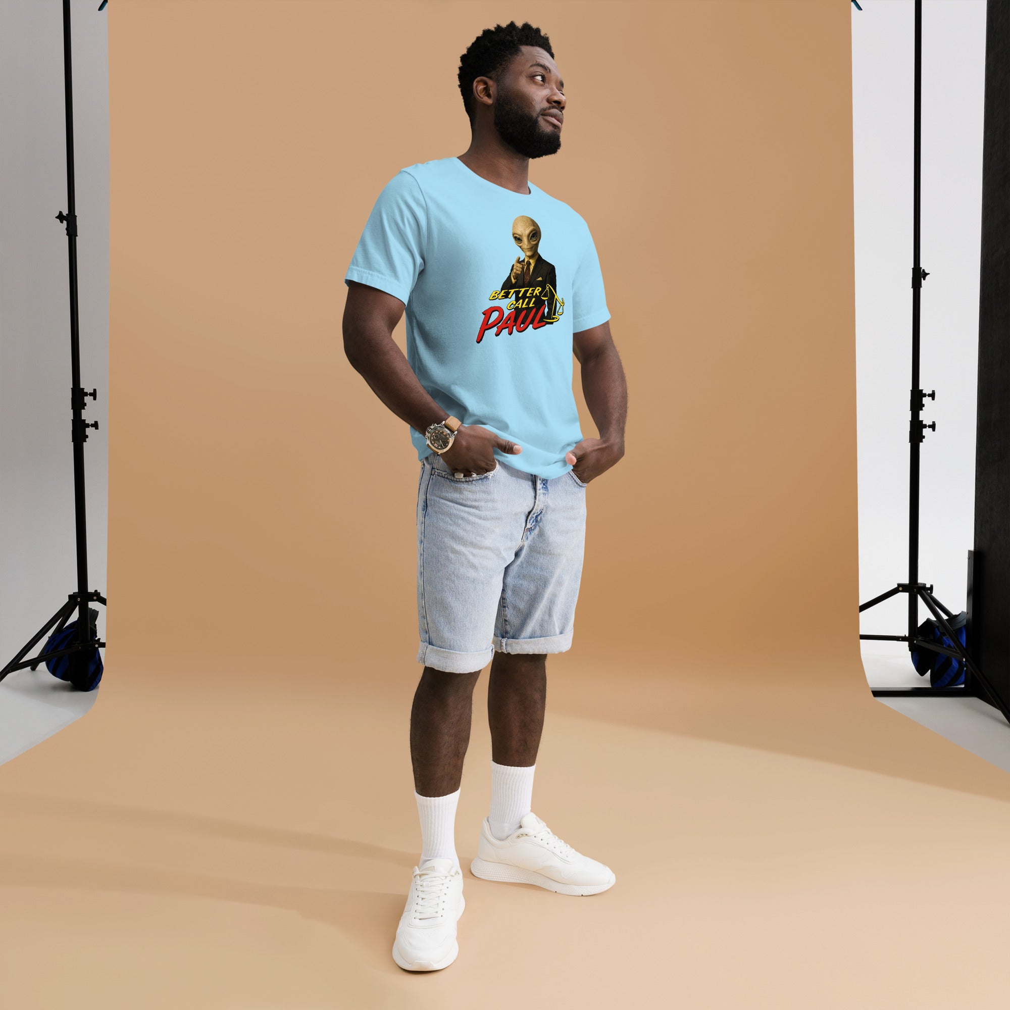 Man wearing a light blue t-shirt with graphic design on a brown backdrop