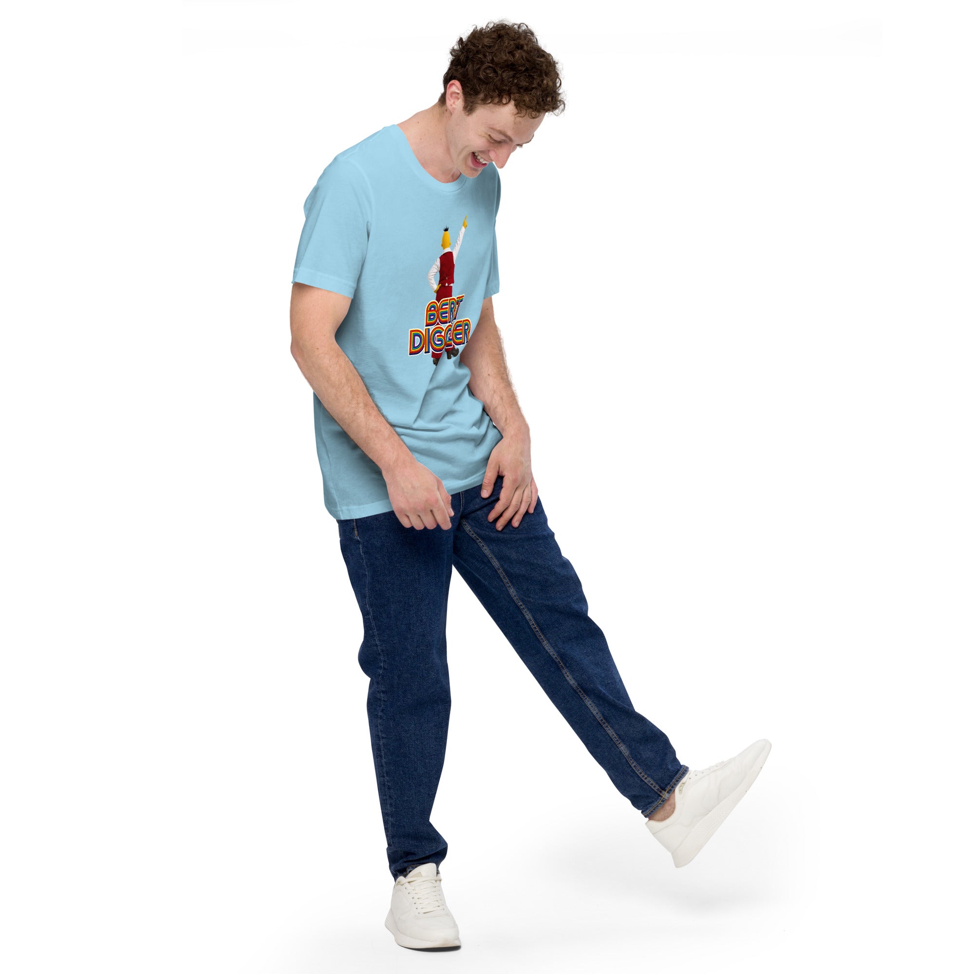 Person wearing a light blue mashforge Bert Diggler t-shirt with a graphic design and dark blue jeans on a white background