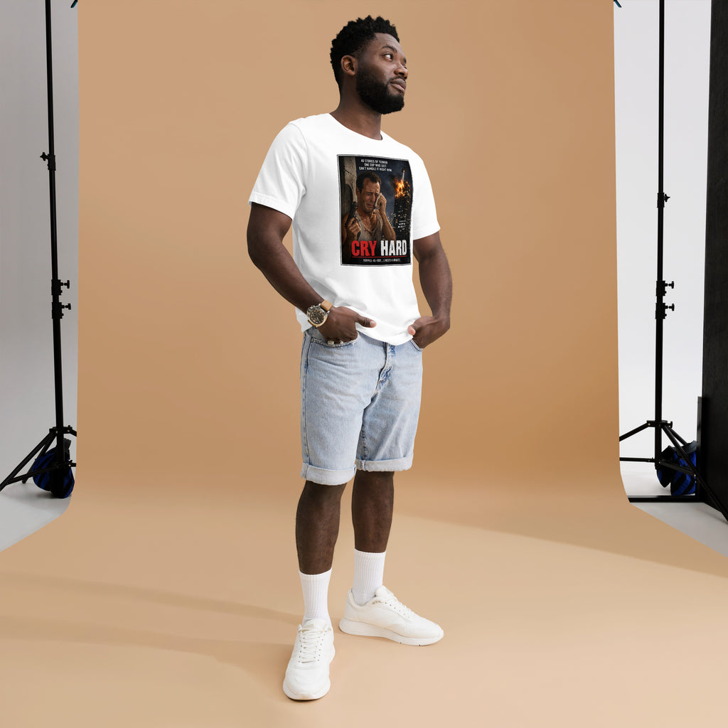 Man wearing a white t-shirt with a graphic design, standing against a brown backdrop in a studio setting.