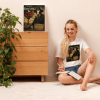 Woman sitting on the floor with a book, next to a wooden dresser with a poster on top.