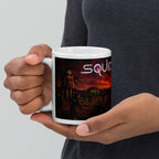 Person holding a mug with a 'Squid' design on a plain background