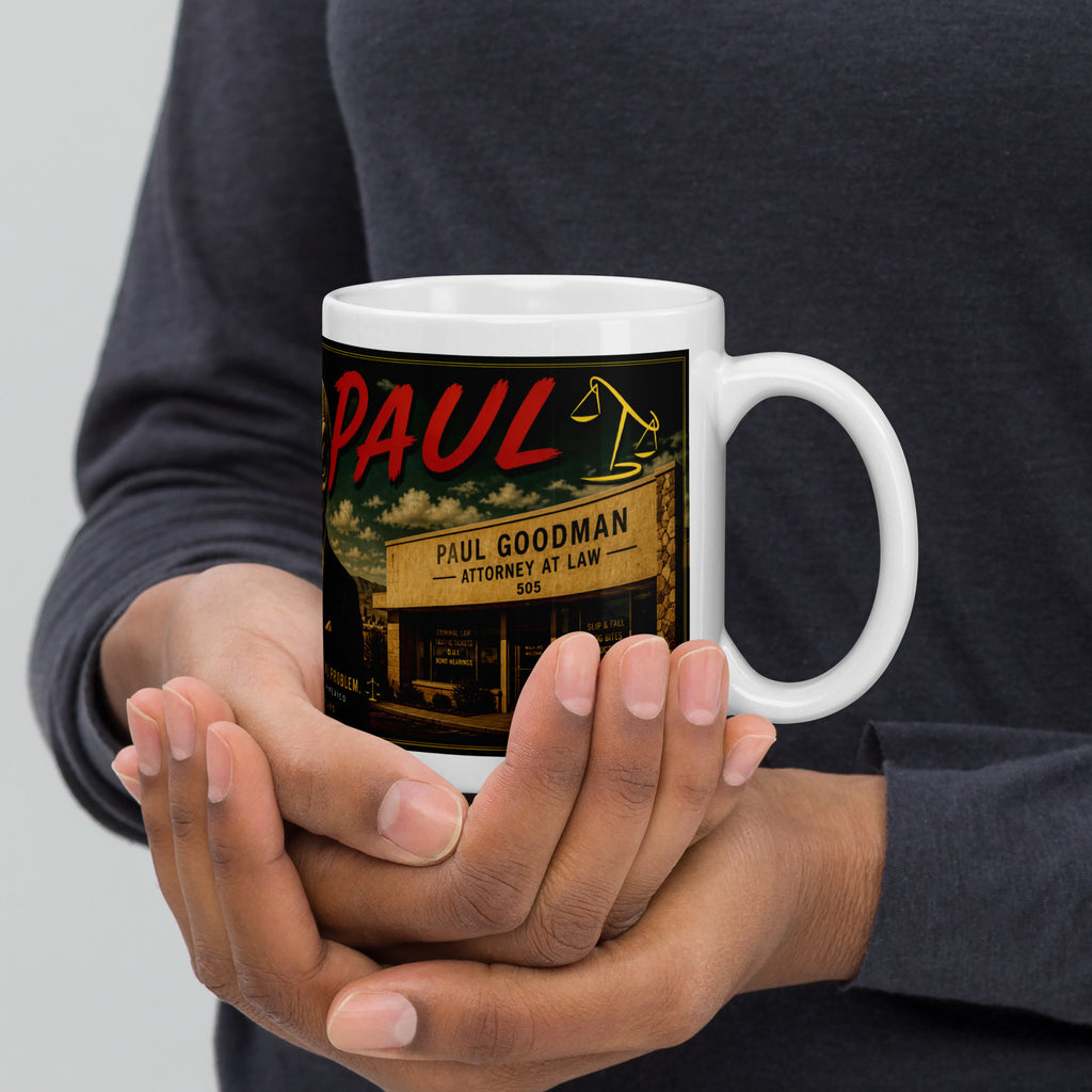 Person holding a mug with a graphic design featuring 'Saul Goodman' attorney at law.